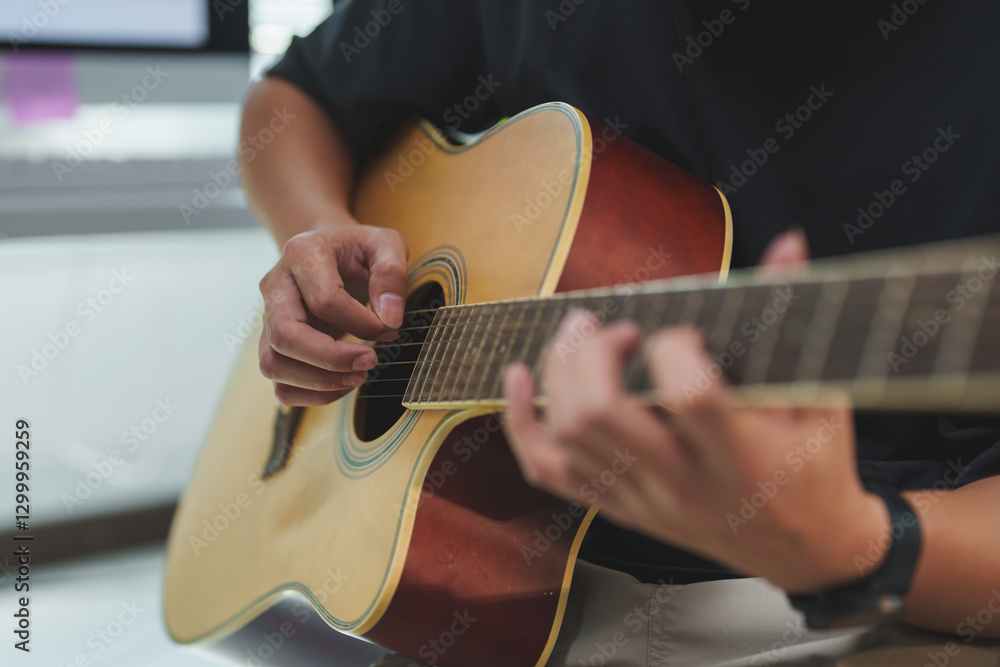 Fototapeta premium Close-up view of a musician skillfully playing an acoustic guitar, fingers deftly navigating the strings while creating beautiful melodies in a cozy home studio environment