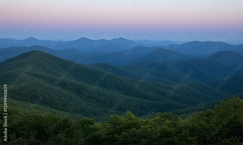 Naklejka premium Serene twilight view of rolling blue mountains, showcasing layers of forested hills under a soft pastel sky. Perfect for nature, travel, and calmness themes.