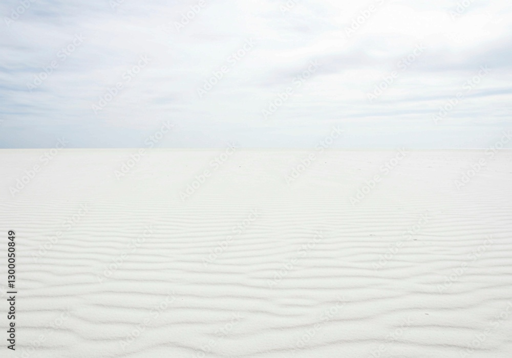Fototapeta premium The minimalist beauty of white sand is highlighted in this image, featuring distinct ripple patterns and natural lighting