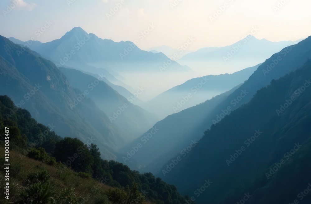 Fototapeta premium Misty mountain landscape with sunlit valleys and layers of blue peaks