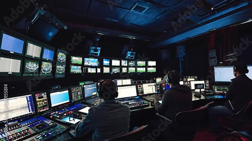 Television broadcast control room with multiple screens and operators