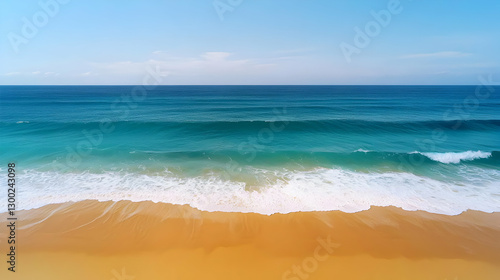 Obraz na płótnie Aerial View of Blue Ocean Waves Crashing onto Sandy Beach Under Clear Sky w salonie
