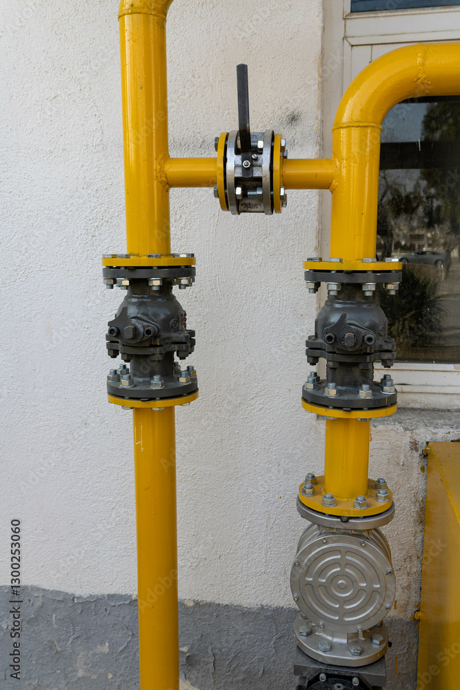 Gas pipe with shut-off valves and a valve near the building. Industrial gas supply system. Gas pipe with shut-off valves and a valve near the building. Industrial gas supply system.