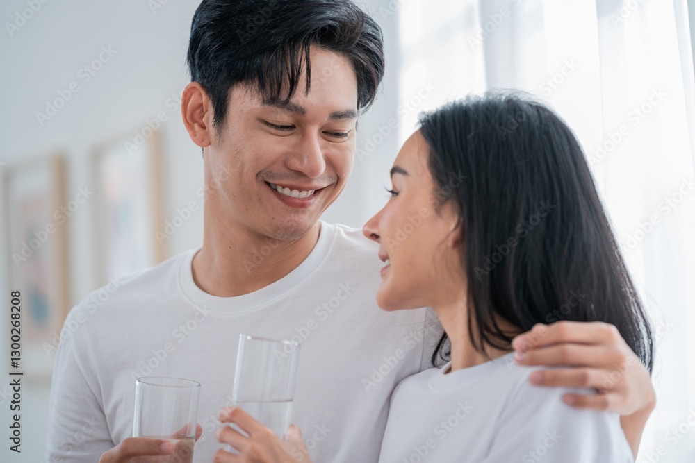 Happy couple shares a warm moment while enjoying drinks indoors during the afternoon light Happy couple shares a warm moment while enjoying drinks indoors during the afternoon light