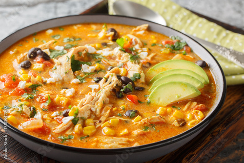 Mexican food Chicken enchilada soup spicy, hearty, and thick closeup on the plate on the table. Horizontal