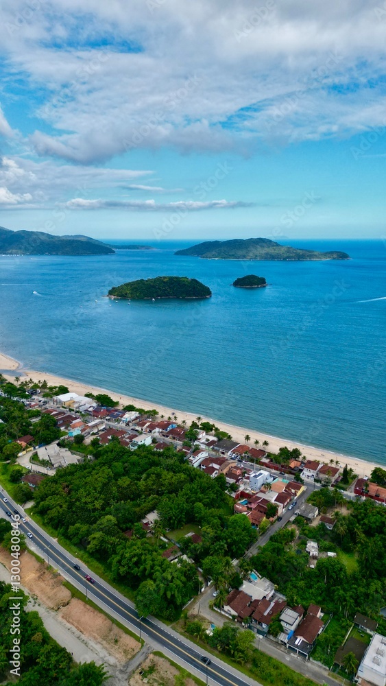 Obraz premium Linda vista aerea com drone sobre o mar com montanhas e cidade ao fundo com cores vibrantes.