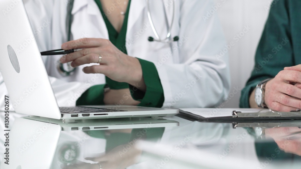 Female doctor showing medical exam results on a laptop to a patient during a visit at the clinic, healthcare and medical consultation concept Female doctor showing medical exam results on a laptop to a patient during a visit at the clinic, healthcare and medical consultation concept