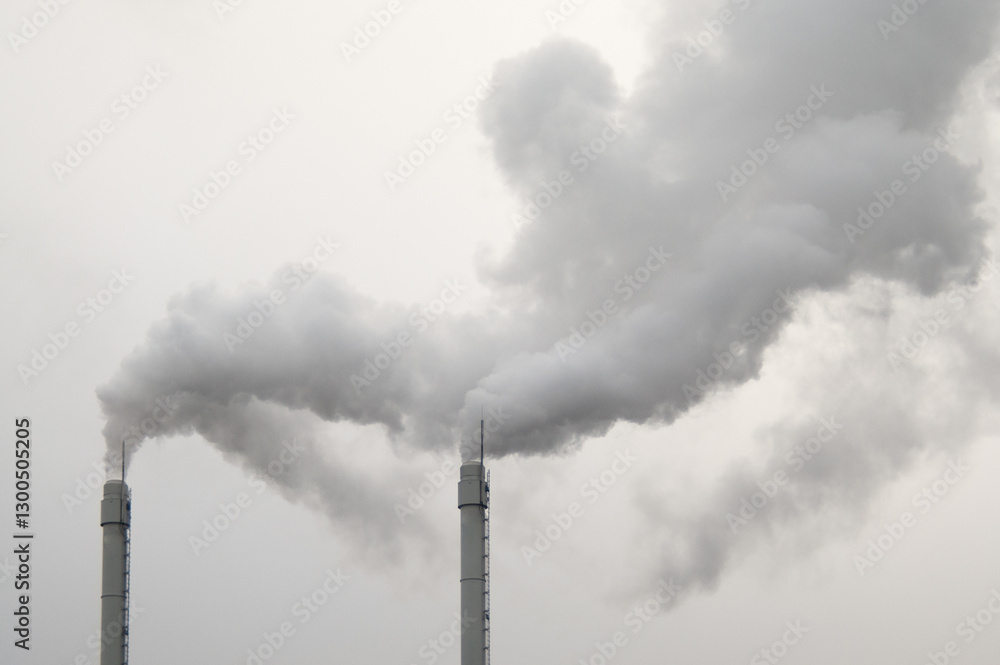 factory chimneys with smoke coming out, gray sky in the background factory chimneys with smoke coming out, gray sky in the background