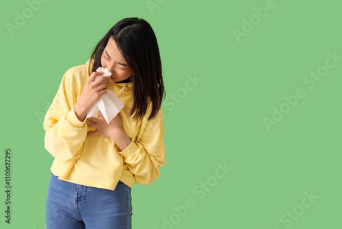 Ill Asian woman with tissue...