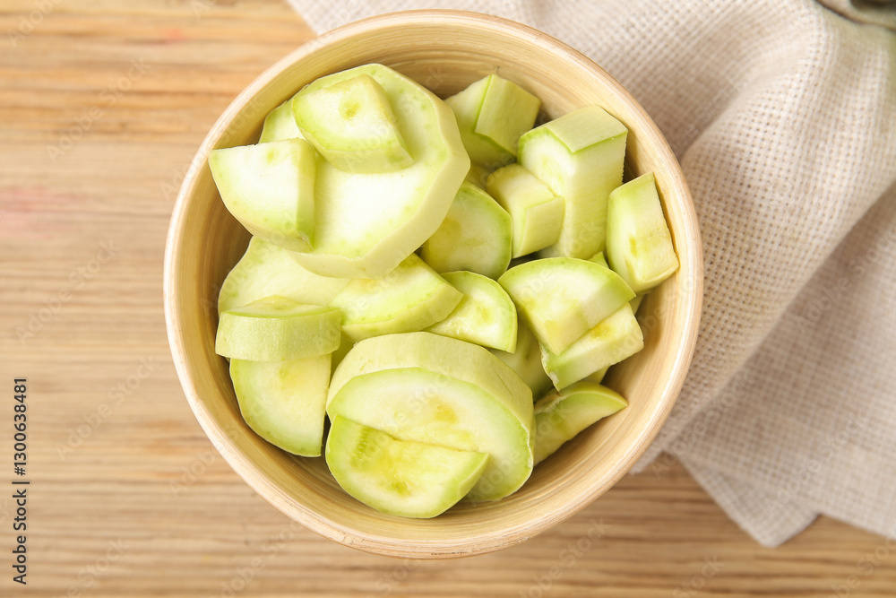 Bowl with pieces of fresh green zucchini on wooden background Bowl with pieces of fresh green zucchini on wooden background