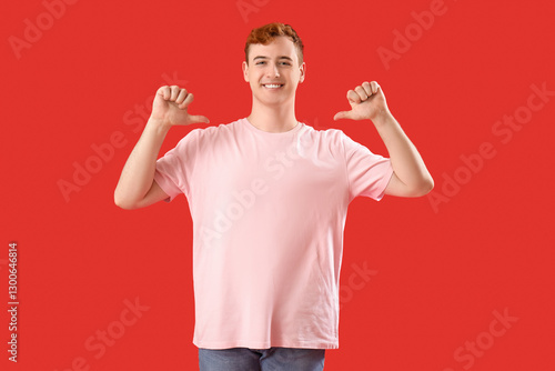 Young man pointing at his t...