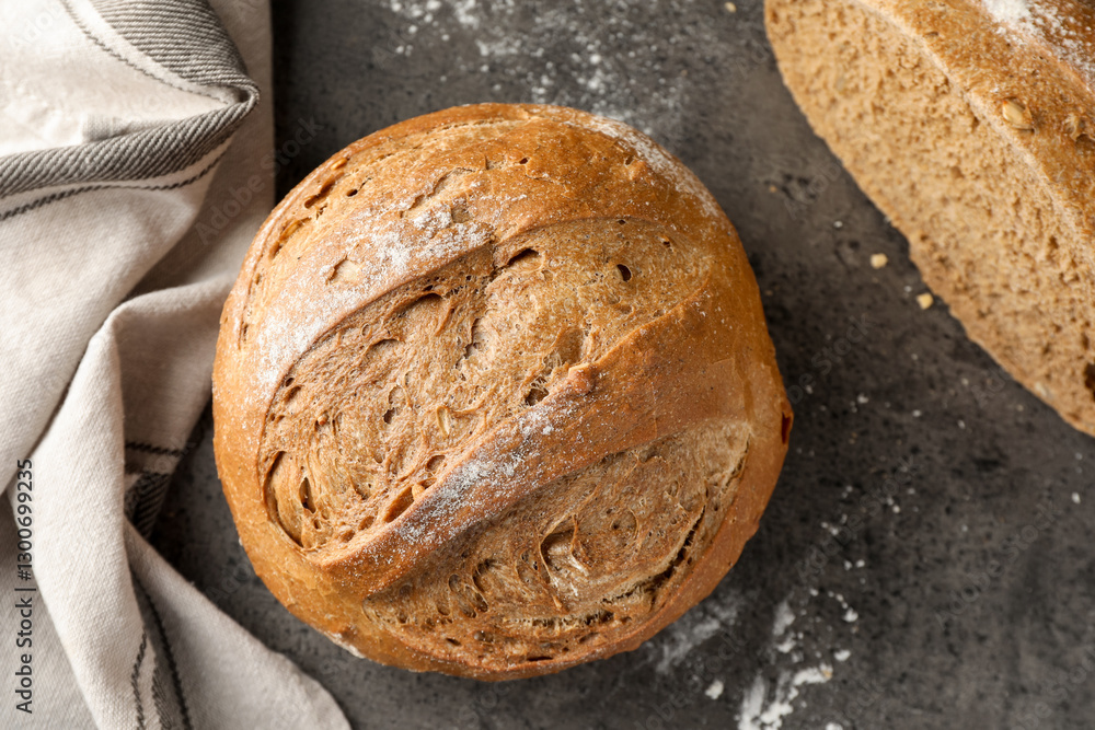 Naklejka premium Whole and cut fresh bread on grey table, top view