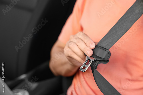 Man fastening seat belt in ...