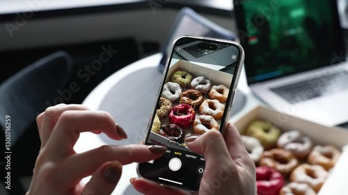 Close up of mobile phone, girl taking picture of box of sweet donuts