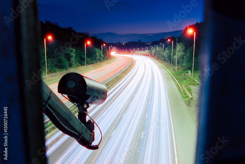 ANPR camera above a UK road, roadway, motorway, surveillance, light trails from moving traffic