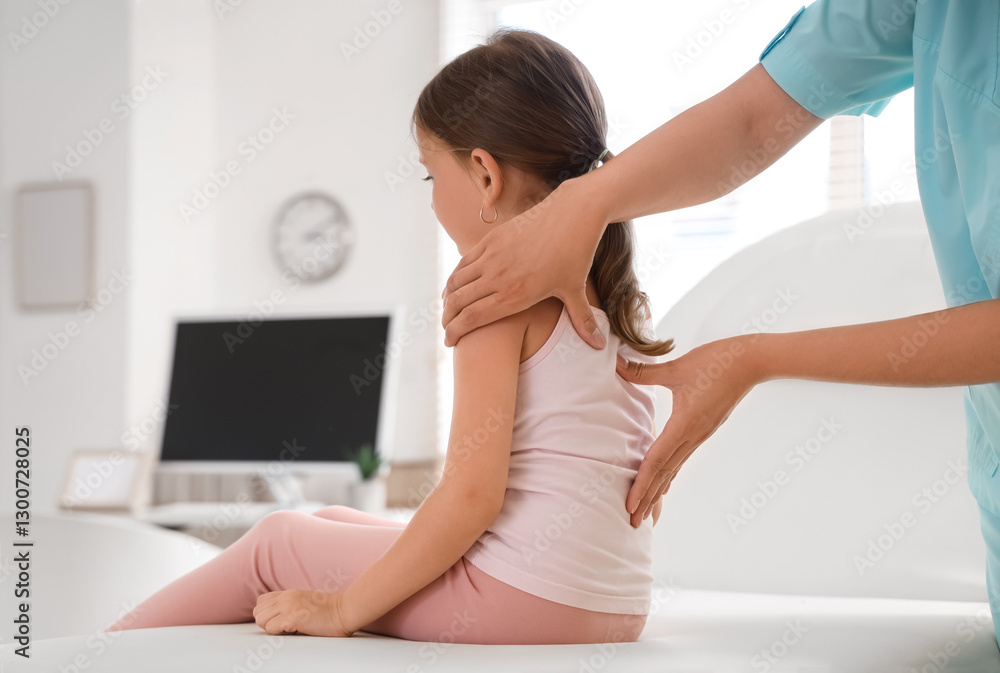 Female osteopath working with little patient in clinic, back view Female osteopath working with little patient in clinic, back view