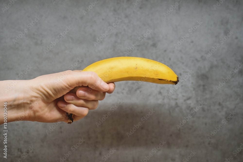 Ταπετσαρία Hand Holding Banana Like a Gun Against Concrete Wall