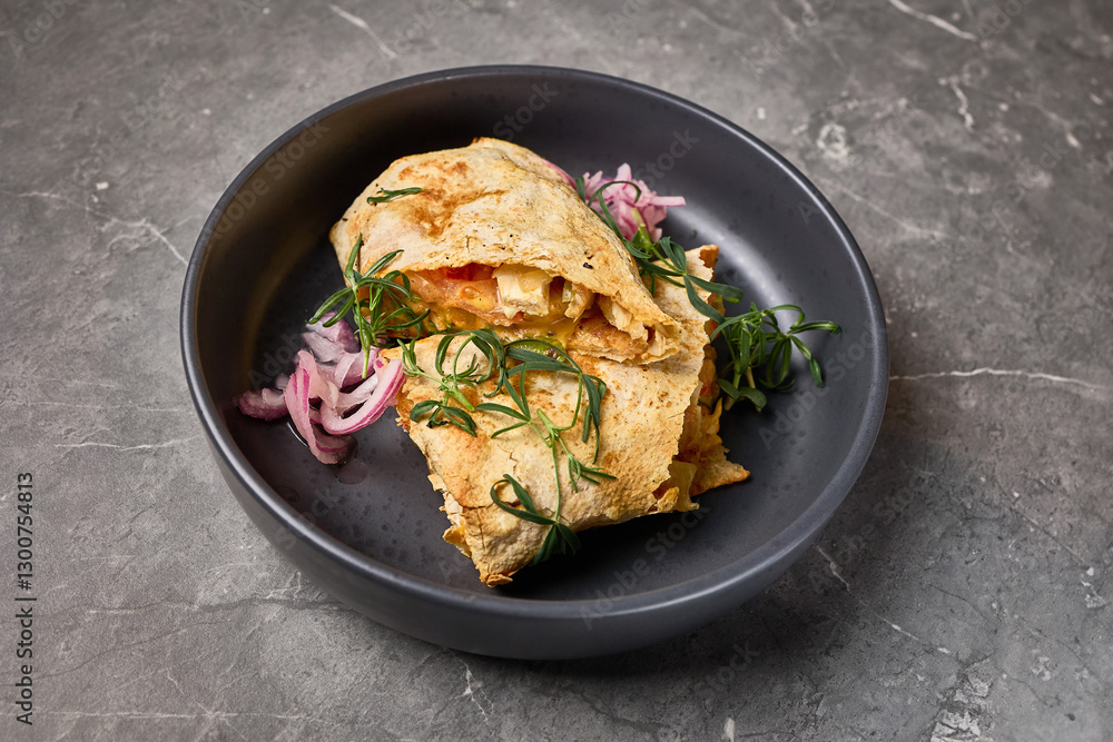 Delicious cheesy quesadilla with fresh herbs and onions served on dark plate, stone background, closeup view, Mexican food concept