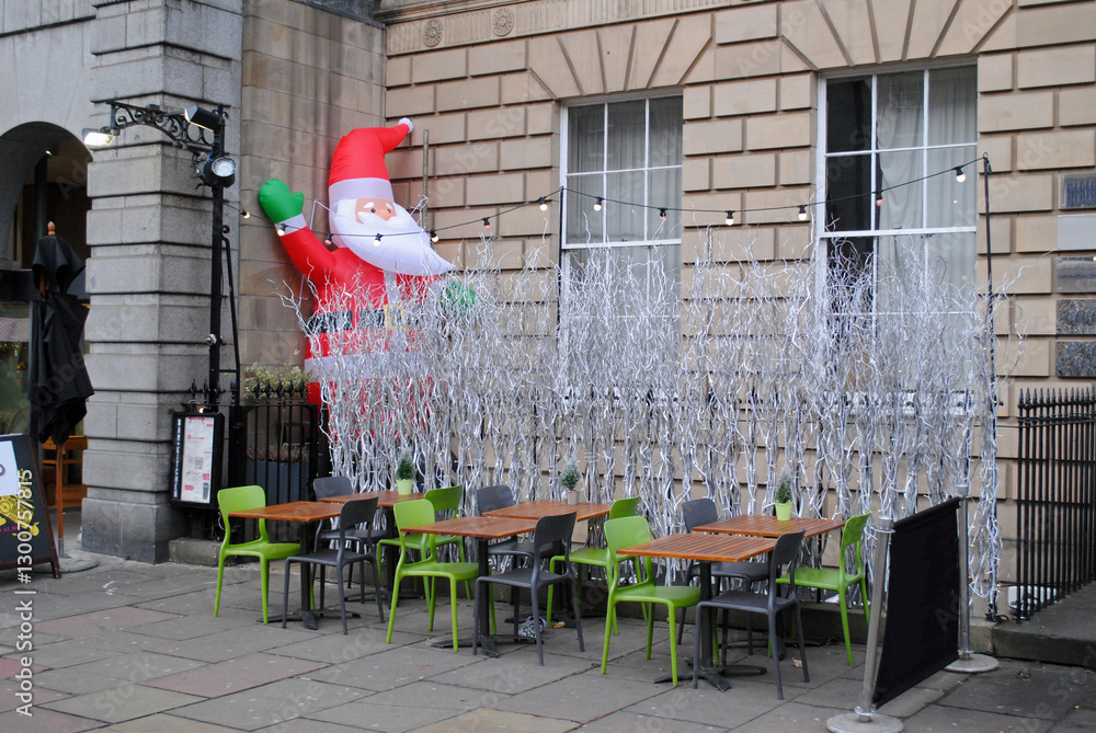 Obraz premium Outdoor Seating Area on Pavement with Inflatable Santa Claus