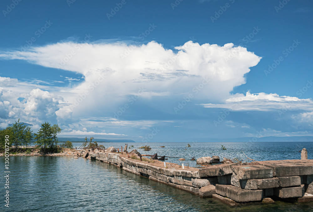 Obraz premium Clouds loom over a tranquil lakeside pier in a serene afternoon landscape