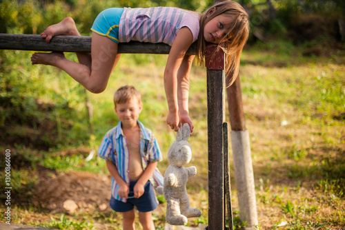 Obraz na płótnie Children, a brother and sister, playing together in a village during summer, radiating joy and innocence. w salonie