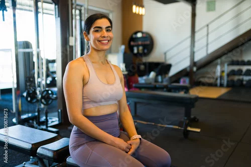 Panel kuchenny z motywem Portrait of a cheerful fitness enthusiast sitting and resting on a bench after exercising at a modern gym