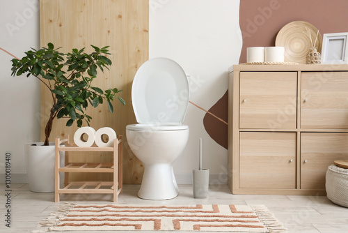 Interior of restroom with toilet bowl, stand and commode