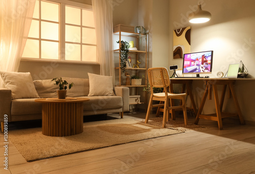 Computer with launched video game on table in stylish living room at evening
