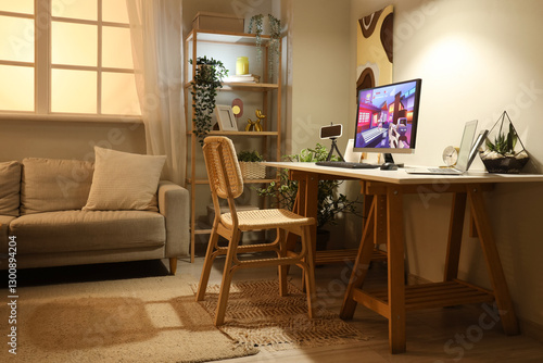 Computer with launched video game on table in stylish living room at evening