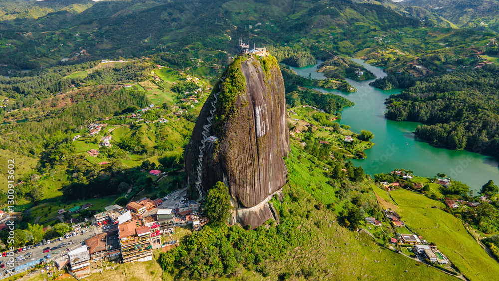 Fototapeta premium Aerial View of El Peñol Rock in Guatape, Antioquia, Colombia Surrounded by Lush Green Landscape and Lake