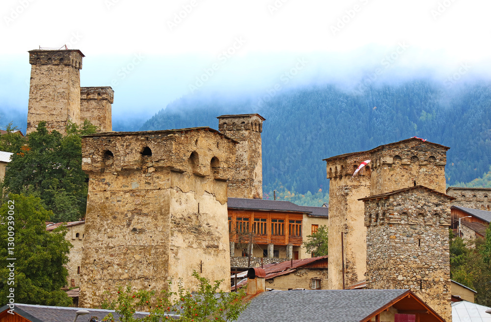 Obraz premium Group of Ancient Svan Tower-houses in the Mist, Incredible UNESCO World Heritage Site in Mestia, Svaneti Region of Georgia