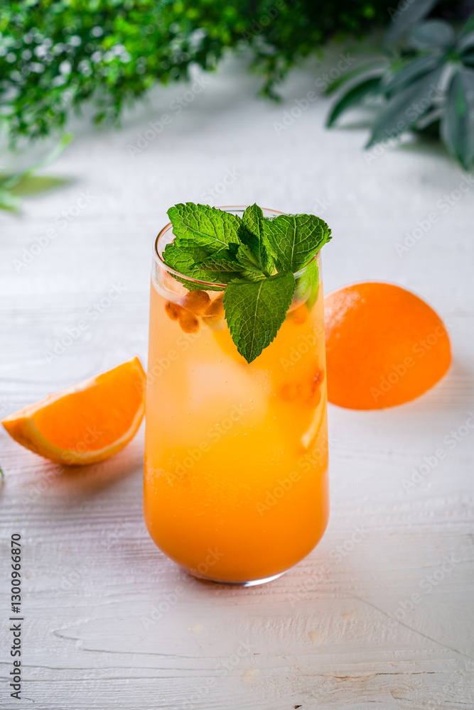 Fototapeta premium orange lemonade on a white table, vertically