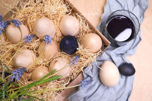 Easter wooden eggs, not colored, are in a box in shavings
