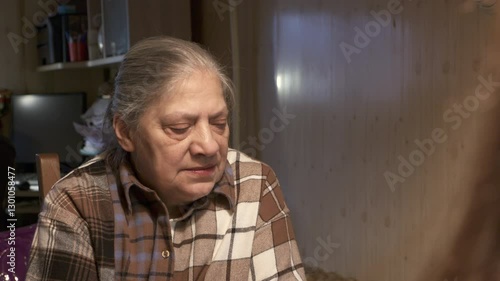 Wallpaper Mural elderly woman with graying hair sits in living room, engaged in an animated conversation. Her expression is earnest and passionate as she speaks sharing story or expressing her thoughts and feelings. Torontodigital.ca