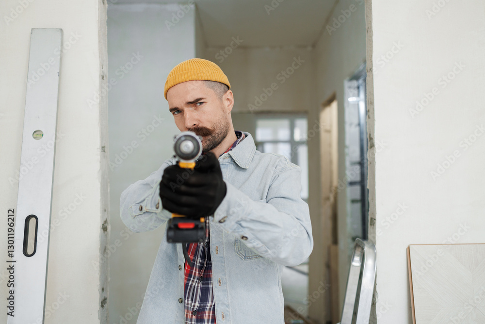 construction worker guy with a drill on a white wall background.master for an hour. construction worker guy with a drill on a white wall background.master for an hour.
