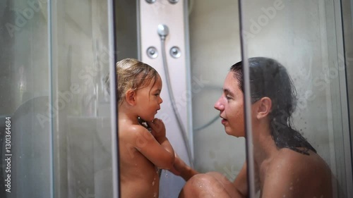 Mom with a little girl are washing in the shower . High quality 4k footage