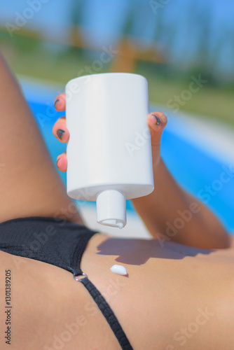 Beautiful and sexy woman, bikini, summer, putting sunscreen on her skin, swimming pool