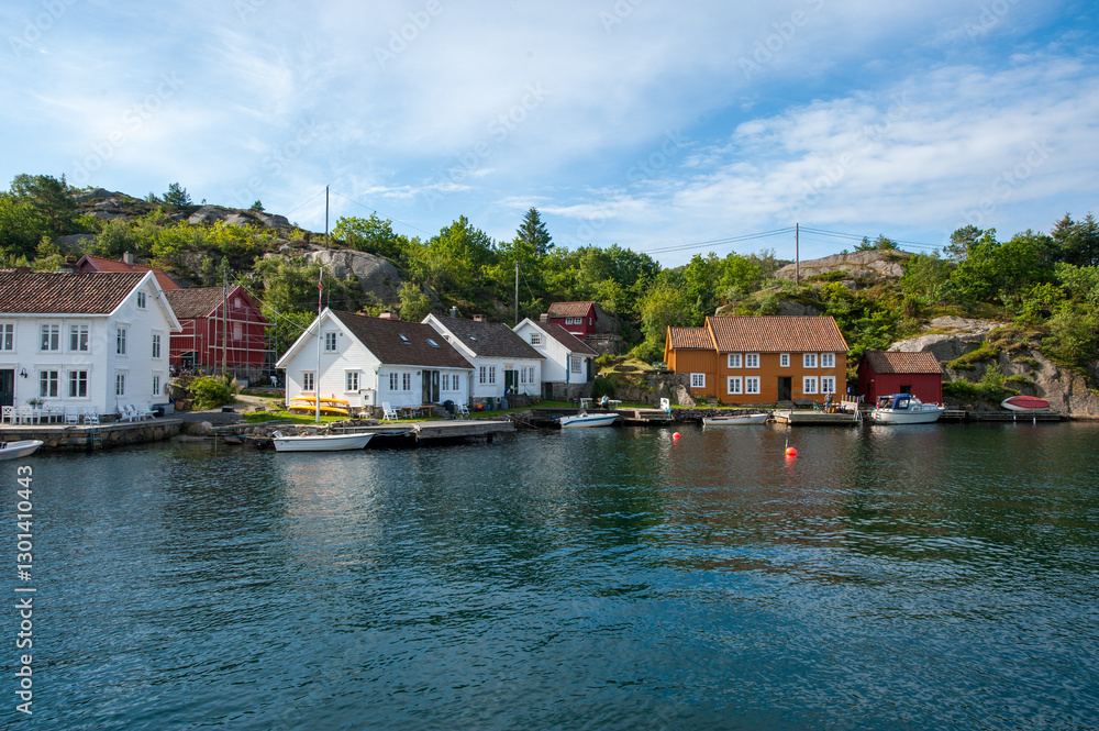 Fototapeta premium picturesque waterfront village with boats and lush greenery.