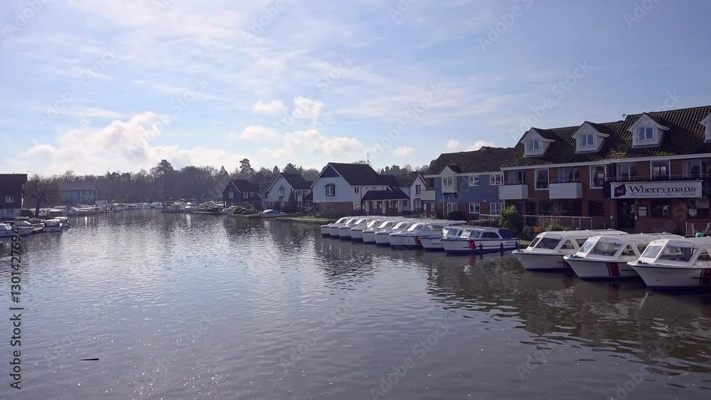 View down the River Bure as seen from the bridge in Wroxham, a small but popular tourist destination. Captured on a bright and sunny morning in the springtime View down the River Bure as seen from the bridge in Wroxham, a small but popular tourist destination. Captured on a bright and sunny morning in the springtime