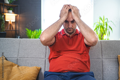 Man sitting alone at home looking sad and distraught photo