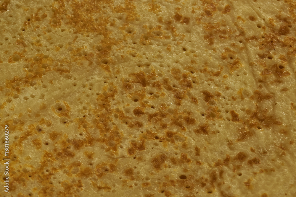 Homemade pancakes for celebrating Pancake day. Thin, ruddy pancakes on Shrovetide with a golden crust and holes. Close-up. Homemade pancakes for celebrating Pancake day. Thin, ruddy pancakes on Shrovetide with a golden crust and holes. Close-up.