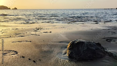 Wallpaper Mural Volcanic black sand and stone from solidified lava close-up against a beautiful sunset and calm Atlantic Ocean. Playa de la Arena, Canary Islands, Tenerife, Spain. Beautiful landscape. Torontodigital.ca