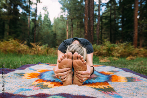 young woman doing yoga in the forest 
