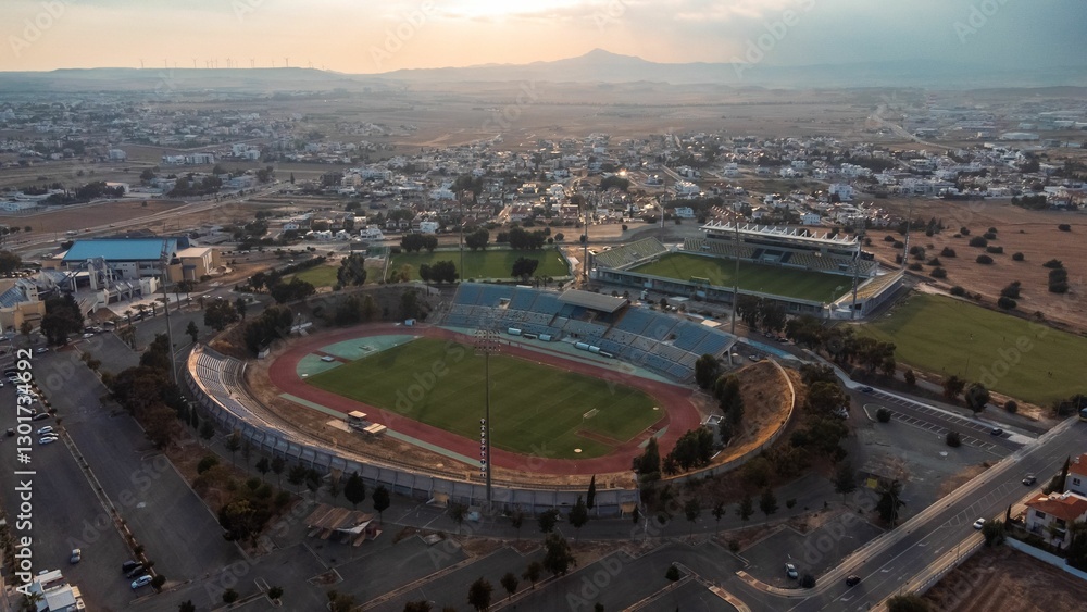 Fototapeta premium Aerial view of a large stadium in a suburban area at sunset.