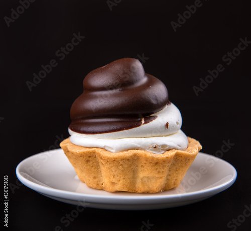 chocolate cake (minitart) on a white plate on dark background