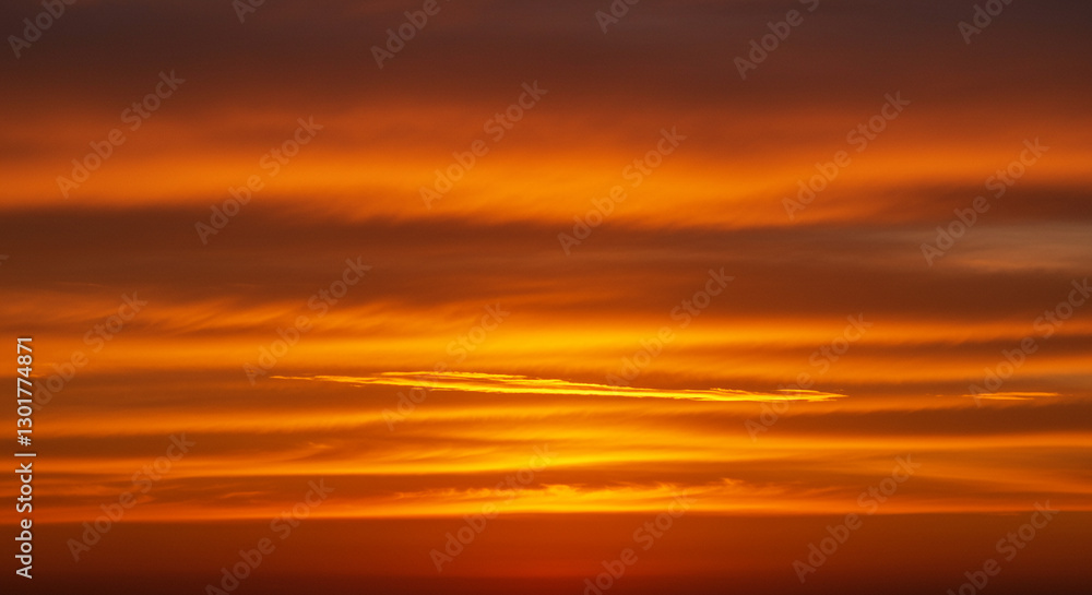 Fototapeta premium Dramatic golden sunset with deep orange sky reflections