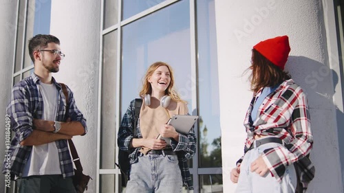Wallpaper Mural Students with backpacks gather outside a modern university, sharing ideas and enjoying each other's company, dressed casually in flannel shirts and comfortable clothes. Torontodigital.ca