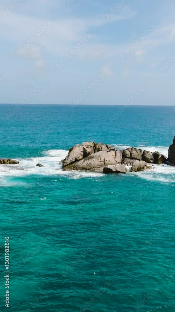 Rock formations surrounded by clear turquoise water with gentle waves on a sunny day. Seychelles, Mahe. Rock formations surrounded by clear turquoise water with gentle waves on a sunny day. Seychelles, Mahe.