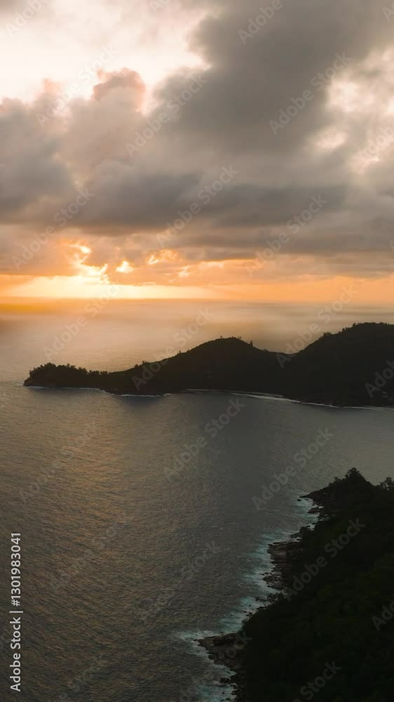 Cloudy sunset over the vast ocean with a silhouetted coastline. Seychelles, Mahe. Cloudy sunset over the vast ocean with a silhouetted coastline. Seychelles, Mahe.