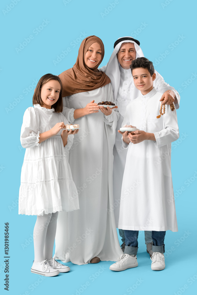 Happy Muslim family with traditional sweets on blue background. Eid al-Fitr celebration Happy Muslim family with traditional sweets on blue background. Eid al-Fitr celebration